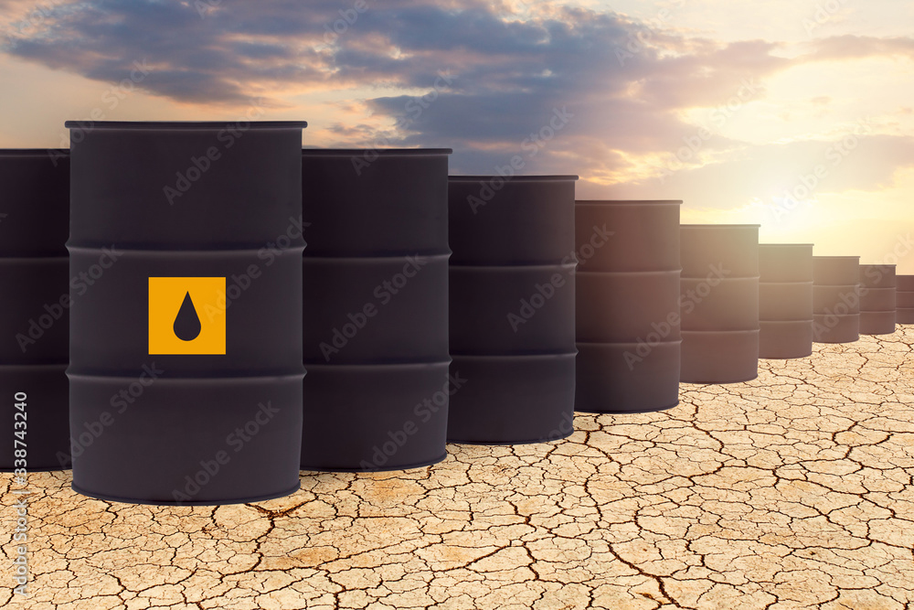 Une grande quantité de baril de pétrole dans un décor de terre asséchée.